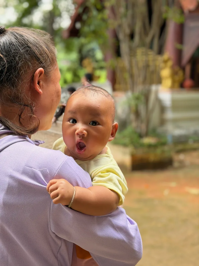 A woman carrying a baby at the village temple