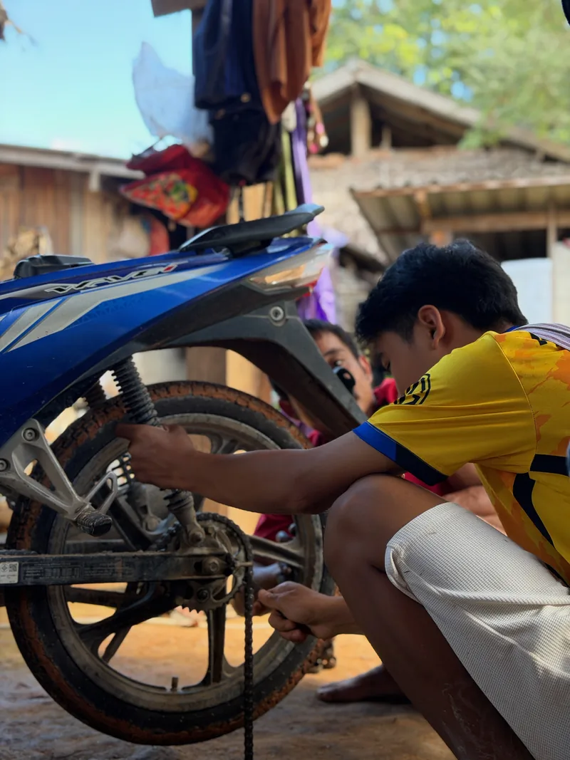 A young villager repairing a motorbike